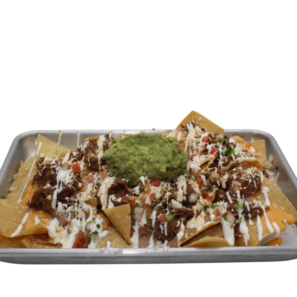 A tray of loaded nachos with pulled pork, cheese, sour cream, pico de gallo, and guacamole.